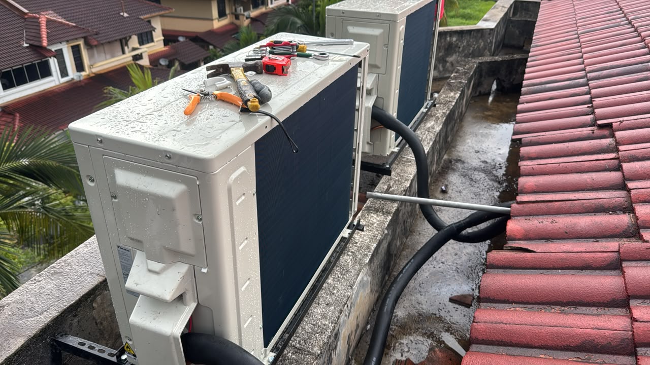 Dua unit outdoor aircond baru di pelantar bumbung dengan peralatan di atasnya